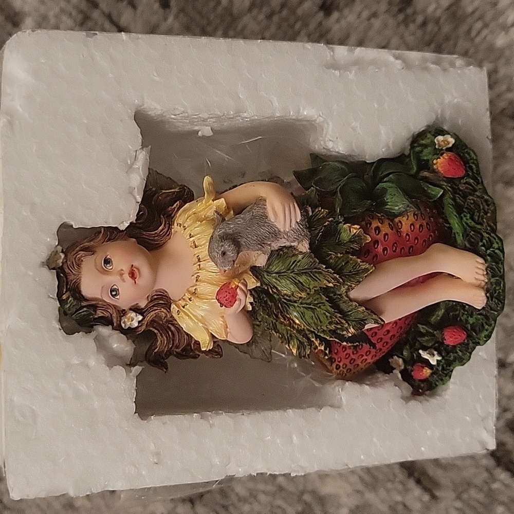 Little girl fairy sitting on a strawberry